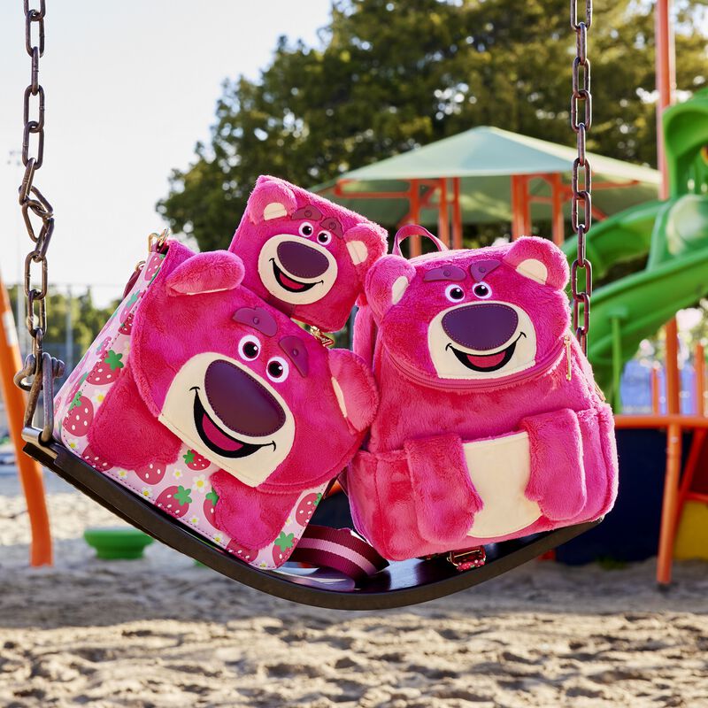 Image of the Lotso Mini Backpack, Crossbody bag, and Wallet piled together on a park swing